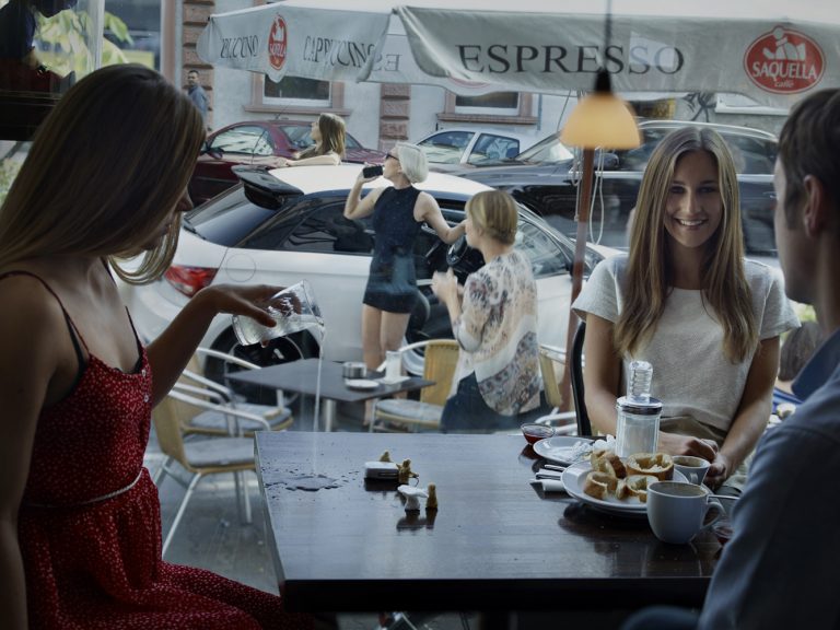 Woman spilling water on table at coffee shop